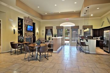 Las Vegas apartment for rent - A spacious living room with a stone fireplace and a dining table set up.