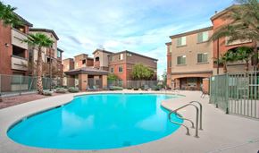 Henderson apartment for rent - A swimming pool surrounded by a fence and buildings.