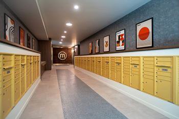 Mail room with golden mailboxes and wall art