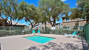 Las Vegas apartment for rent - A pool surrounded by trees and chairs.