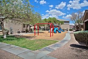 Las Vegas apartment for rent - A playground with a red swing set and a blue slide.