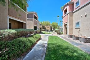 Las Vegas apartment for rent - A sunny day in a residential area with apartment buildings and a sidewalk.