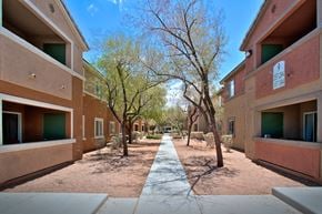 Las Vegas apartment for rent - a courtyard between two buildings with trees and a sidewalk