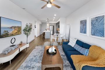 Oxnard apartment for rent - A living room with a blue couch and a painting on the wall.