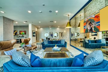 Phoenix apartment for rent - a living room with blue couches and chairs and a large painting