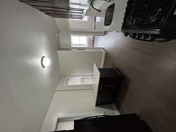 Bayonne apartment for rent - A white wall with a round light fixture and a skylight above a window.