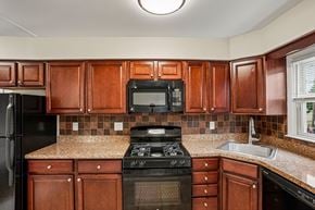 West Caldwell apartment for rent - A kitchen with brown cabinets and black appliances.