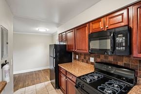 West Caldwell apartment for rent - A kitchen with black appliances and wooden cabinets.