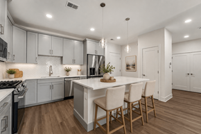 Madison apartment for rent - A modern kitchen with a white island and wooden chairs.