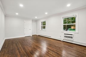 West Caldwell apartment for rent - A room with wooden floors and a window showing trees outside.
