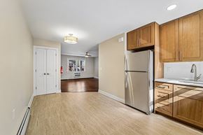 South River apartment for rent - A kitchen with a refrigerator, sink, and wooden cabinets.