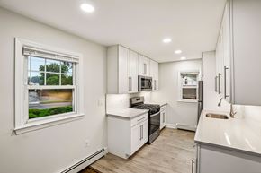 West Caldwell apartment for rent - A white kitchen with a window showing a street view.