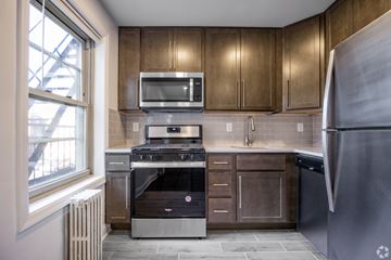 Bayonne apartment for rent - A kitchen with a stove top oven and a microwave above it.