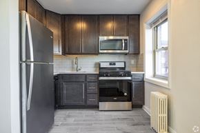 Bayonne apartment for rent - A modern kitchen with dark wood cabinets and stainless steel appliances.