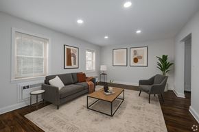 Bayonne apartment for rent - A living room with a grey couch, a coffee table, and a lamp.