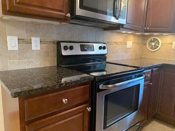 Madison apartment for rent - A black stove top oven with a silver handle is on a kitchen counter.
