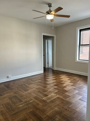 Bayonne apartment for rent - A room with a ceiling fan and wooden flooring.