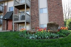 Liberty apartment for rent - A large rock sits in front of a flower bed with red and yellow tulips.
