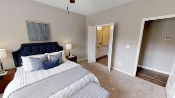 Shawnee triplex for rent - A bedroom with a large bed and a ceiling fan.