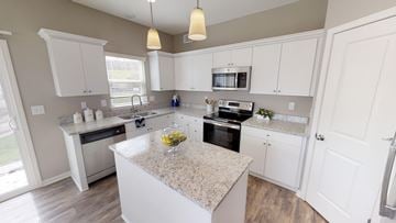 Shawnee triplex for rent - A kitchen with a granite countertop and white cabinets.