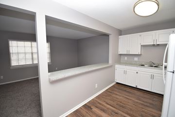 Claycomo apartment for rent - A kitchen with white cabinets and a refrigerator.