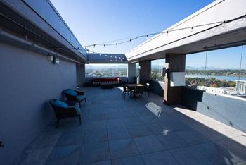 A patio with a table and chairs overlooking a body of water.