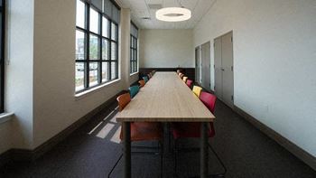 A conference room with a long table and chairs.