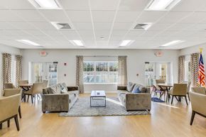 Middle Island apartment for rent - A spacious room with a coffee table in the middle and chairs around it.