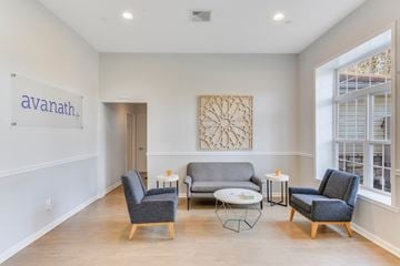 Middle Island apartment for rent - A living room with a couch, chairs, and a table with a sign that says "avanath.".