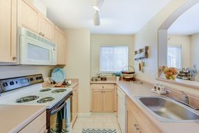 Federal Way apartment for rent - A kitchen with a stove, sink, and microwave at The Lodge at Peasley Canyon in Federal Way, Washington 98001