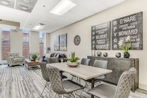 Chicago apartment for rent - A conference room with a long table and chairs, a couch, and a wall with a list of names. at Academy at Drexel Apartments, Chicago, IL, 60637