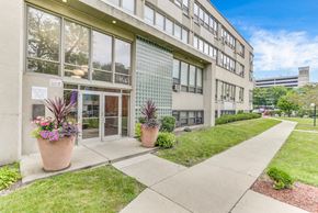 Chicago apartment for rent - A building with a glass facade and a walkway in front. at Academy at Drexel Apartments, Illinois, 60637