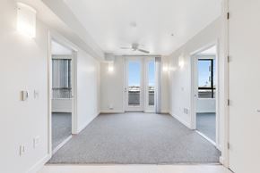 Berkeley apartment for rent - A spacious, empty room with a ceiling fan and carpeted floor. at Acton Courtyard, Berkeley
