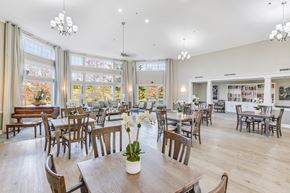Temple Hills apartment for rent - A room with wooden chairs and tables with a vase of flowers on the table in the center at Manor at Victoria Park, Temple Hills, 20748