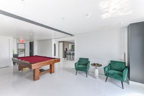 Brooklyn apartment for rent - A room with a pool table, two green chairs and a small table.