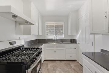 Los Angeles apartment for rent - A kitchen with a black stove top oven and white cabinets.