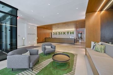 Brooklyn apartment for rent - A modern living room with a green rug and grey couches.
