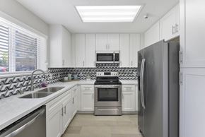 Garden Grove apartment for rent - A modern kitchen with white cabinets and stainless steel appliances.