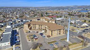 Denver apartment for rent - A large building with a parking lot in front of it.at Sable Ridge Senior Residences South, Denver Colorado