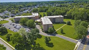 Edison apartment for rent - A large building with a parking lot in front of it at Menlo Manor Apartments, Edison, New Jersey