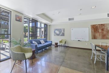 San Francisco apartment for rent - A living room with a blue couch and a whiteboard on the wall.