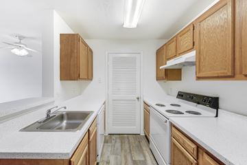 Sterling apartment for rent - A kitchen with wooden cabinets and a white countertop.