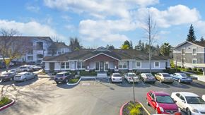 Elk Grove apartment for rent - A parking lot with cars and a building in the background.