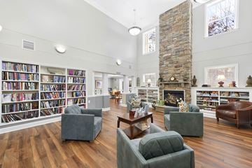 Edgewater apartment for rent - A living room with a stone fireplace and a bookshelf filled with books.
