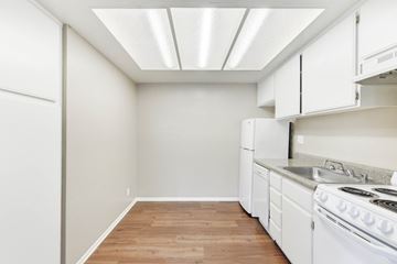 Ontario apartment for rent - A kitchen with white appliances and wooden floors.