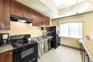 Yorba Linda apartment for rent - A kitchen with a black stove top oven and black refrigerator.