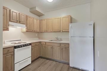 Edison apartment for rent - A kitchen with wooden cabinets and a white refrigerator.