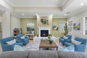 North Highlands apartment for rent - Community lounge with blue seating and fireplace at Corsair Park Senior Apartments, North Highlands