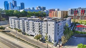 Los Angeles apartment for rent - A large white building with a red awning sits on the corner of a street.