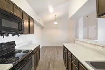 Denver apartment for rent - A kitchen with black appliances and wooden cabinets.